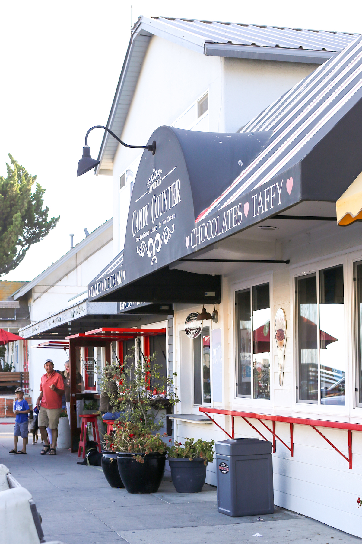 Exterior of the Candy Counter shop with it's black awnings and red bar